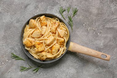 Pişmiş tavuklu kızartma tavası ve Grunge arka planında makarna.