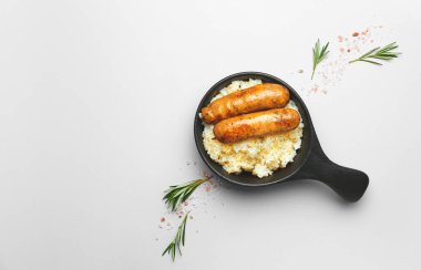 Pişmiş sosisli tava ve hafif arka planda pilav.