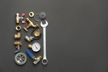 Koyu arkaplanda tesisatçı eşyaları var.