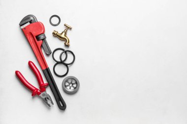 Açık arkaplanda tesisatçı eşyaları var.