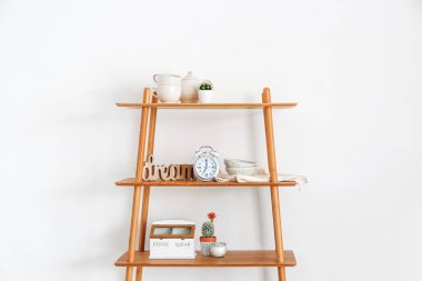 Alarm saati ve ışık duvarının yanındaki dekorlu rafta.