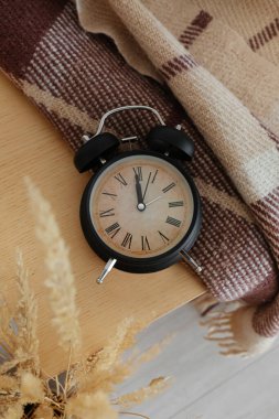 Odadaki ahşap masadaki çalar saat.