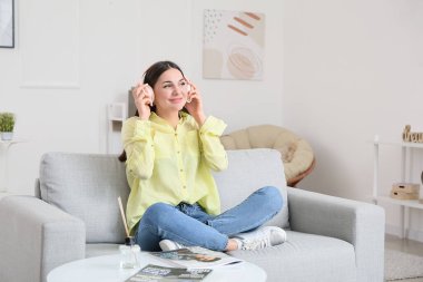 Evde müzik dinleyen genç bir kadın