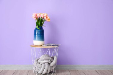 Lale çiçeği buketi ve dergi renkli duvarın yanındaki masada.