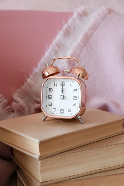 目覚まし時計と部屋のアームチェアに関する本 — ストック写真