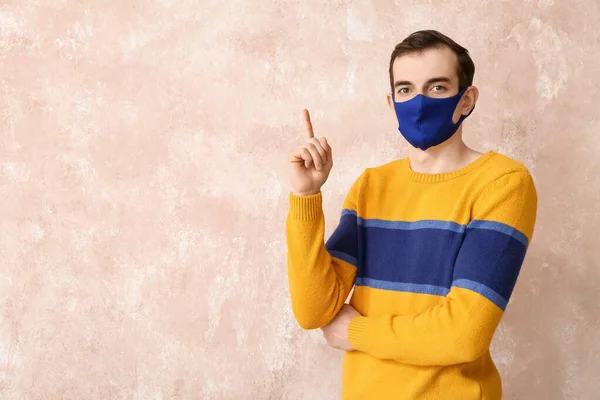 Hombre Joven Con Máscara Médica Apuntando Algo Fondo Color — Foto de Stock