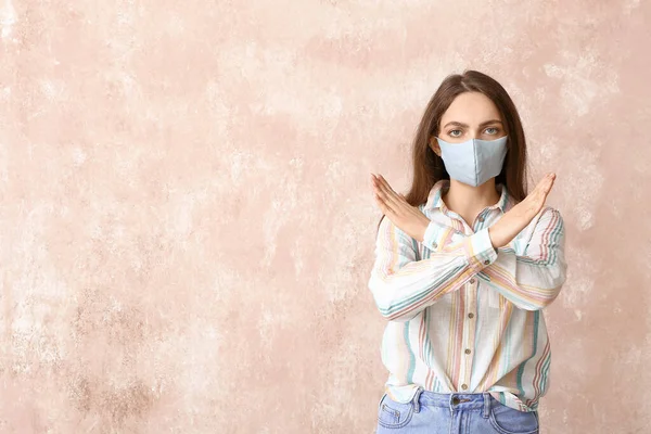 若い女性は医療マスクを着用し 色の背景にストップジェスチャーを示します — ストック写真