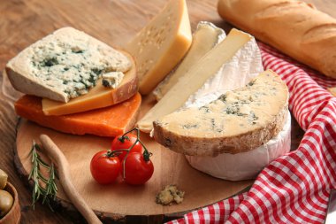 Ahşap arka planda farklı peynir çeşitlerine sahip kompozisyon