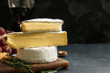 Koyu arkaplanda lezzetli peynir parçaları, yakın plan.