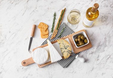 Lezzetli peynirli pano, hafif arka planda atıştırmalık ve şarap.