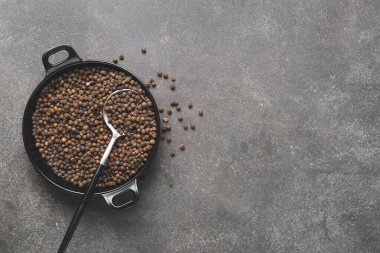 Koyu arkaplanda biberli kase ve kaşık.