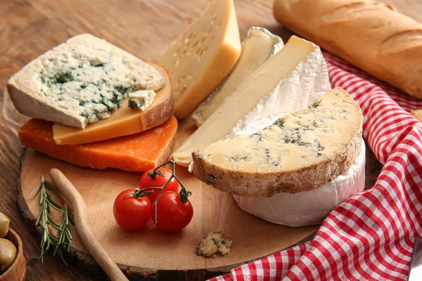 Ahşap arka planda farklı peynir çeşitlerine sahip kompozisyon