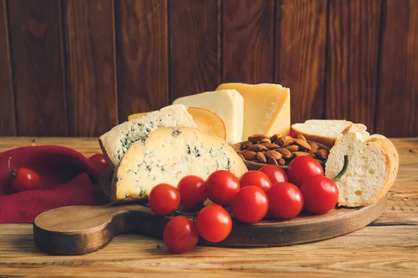 Board Different Types Cheese Tomatoes Nuts Bread Wooden Background — Stock Photo, Image