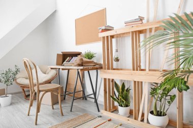 Kitaplar ve ev bitkileriyle aydınlatma odasının içinde.