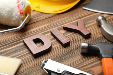 Aletlerden yapılmış çerçeve ve ahşap arka planda kelime DIY, yakın plan