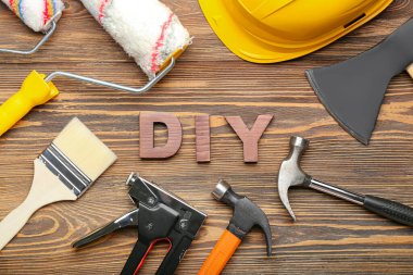 Aletlerden yapılmış çerçeve ve ahşap arka planda kelime DIY