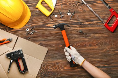 Ahşap arka planda aletleri olan bir kadın el.