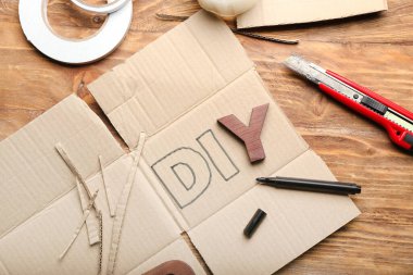 Kelime Diy, tahta arka planda karton ve bıçak.