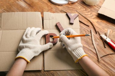 Ahşap zemin üzerinde kalem ve kelime DIY ile kadın eller