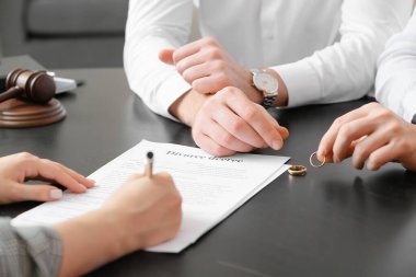 Evlilik yüzüklerini avukatın ofisinde çıkaran bir çift.