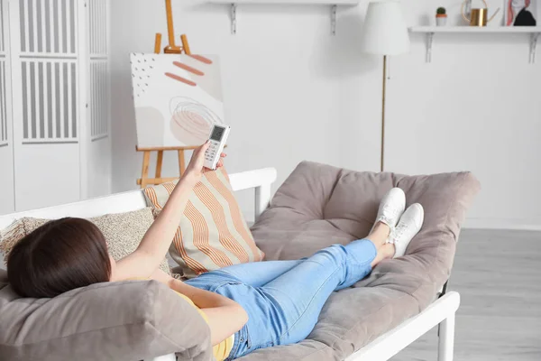 Young Woman Switching Air Conditioner While Lying Sofa Home — Stock Photo, Image