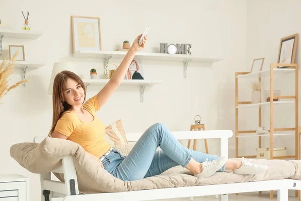 Jonge Vrouw Met Airconditioner Afstandsbediening Thuis — Stockfoto