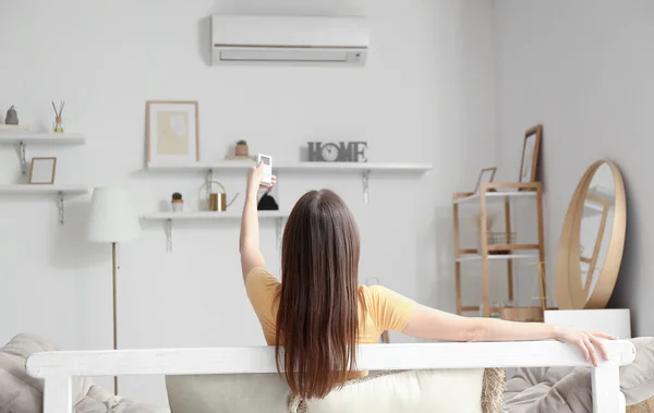 Young Woman Air Conditioner Remote Control Sofa Home — Stock Photo, Image