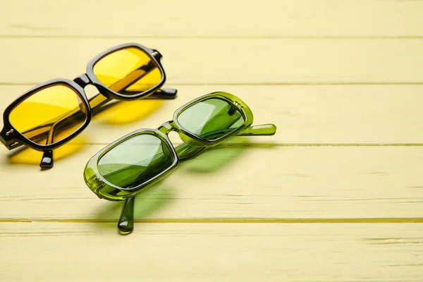 Renkli Ahşap Arka Planda Farklı Modern Güneş Gözlükleri — Stok fotoğraf