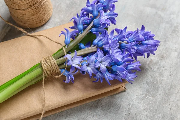 Bouquet of beautiful hyacinth flowers and book on light background, closeup