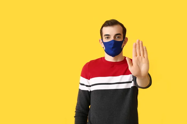 Ung Man Bär Medicinsk Mask Och Visar Stop Gest Färg — Stockfoto