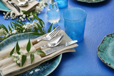 Beautiful table setting with floral decor on color background, closeup