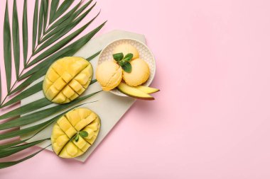 Bowl with tasty mango ice cream and palm leaf on color background
