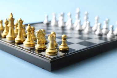 Game board with chess pieces on color background, closeup