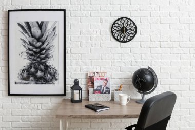 Modern workplace with organizers near brick wall