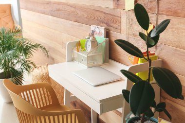 Modern workplace with laptop and organizer near wooden wall