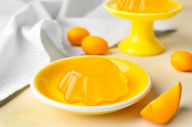 Plate with tasty orange jelly on white background