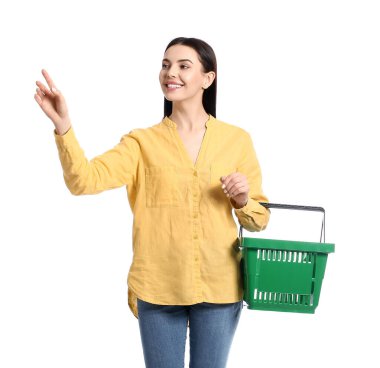 Beyaz arka planda alışveriş sepeti olan genç bir kadın.