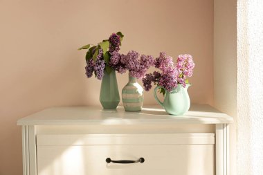 Masada güzel leylak çiçekleri olan vazolar.