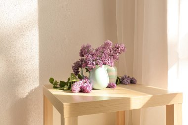 Masada güzel leylak çiçekleri olan vazolar.