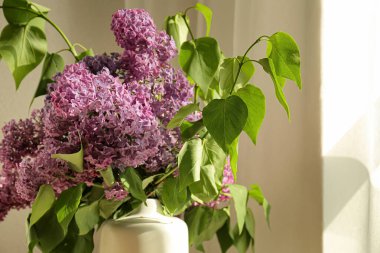 Masada güzel leylak çiçekleri olan vazo.