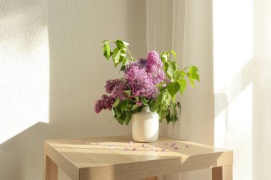 Masada güzel leylak çiçekleri olan vazo.