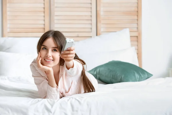 Young Woman Air Conditioner Remote Control Bedroom — Stock Photo, Image