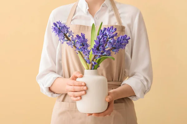 女人拿着花瓶 花瓶上有美丽的水仙花 背景是彩色的 — 图库照片