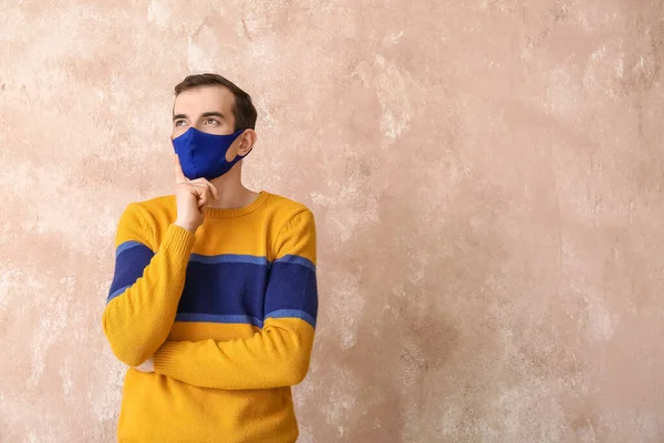 Thoughtful Young Man Wearing Medical Mask Color Background — Stockfoto