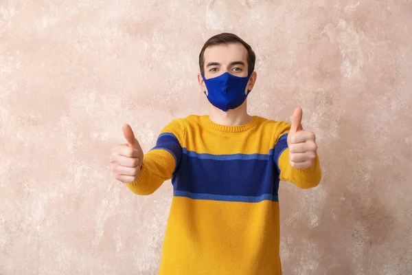 Ung Man Bär Medicinsk Mask Och Visar Tummen Upp Färg — Stockfoto