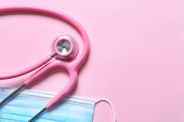 Renkli arka planda modern steteskop ve maske, yakın plan