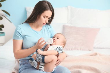 Evde küçük sevimli bir bebeği olan bir anne.