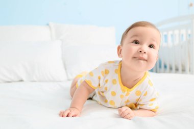 Sevimli küçük bebek yatakta uzanıyor, yakın plan.