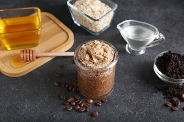 Kavanoz dolusu doğal vücut fırçası ve koyu arkaplanda malzemeler.