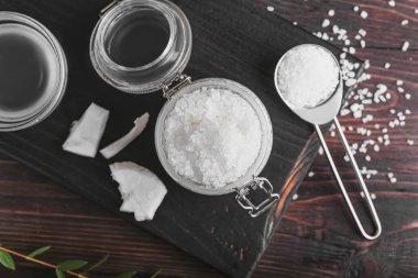 Hindistan cevizi vücut fırçası ve koyu ahşap arka plandaki malzemelerle kompozisyon